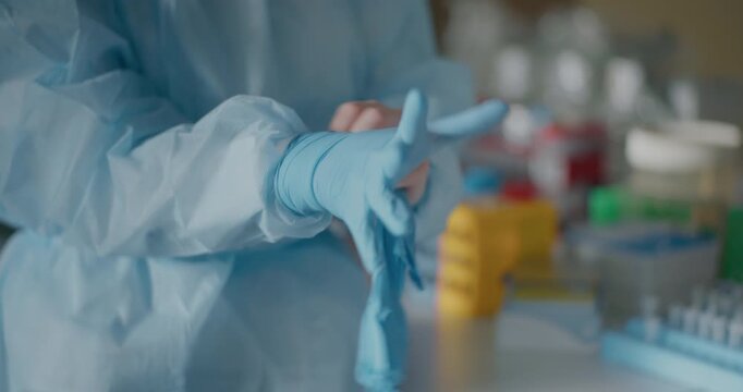 Scientist Donning Protective Gloves in Laboratory