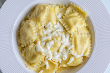 lose-Up of Italian Ravioli with Mozzarella and Olive Oil on a White Plate