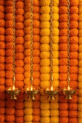 Marigold flower wall backdrop with hanging diyas for Diwali celebration