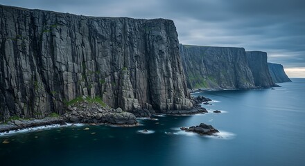 Dramatic coastal cliffs meeting ocean under a cloudy sky landscape