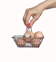 female hand holding chicken eggs in a supermarket grocery basket on a white background. Eggs in shopping cart. the concept of buying and selling eggs. High quality photo