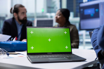 Production plant expert analyzes sustainable manufacturing research and development data using green screen laptop. Investors review documentation files on mockup notebook to evaluate tech innovations