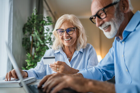 Senior couple enjoying online shopping using laptop and credit card - Powered by Adobe