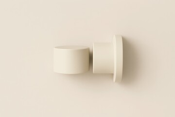 Elegant arrangement of two cream-colored cylindrical objects on a minimalist background.