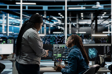 Data center engineers talking, doing brainstorming, using artificial intelligence visualization...