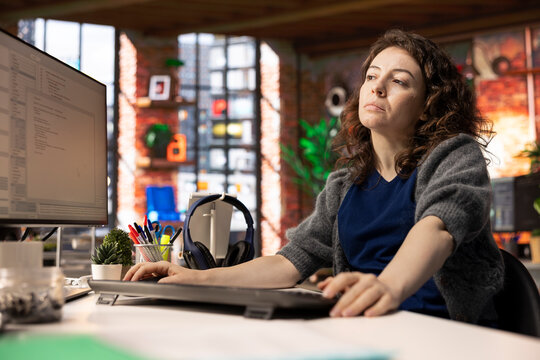 Female programmer developing an app and software algorithm on pc, working at the creative agency. Engineer uses digital tools and focuses on java script engineering and coding, IT specialist.