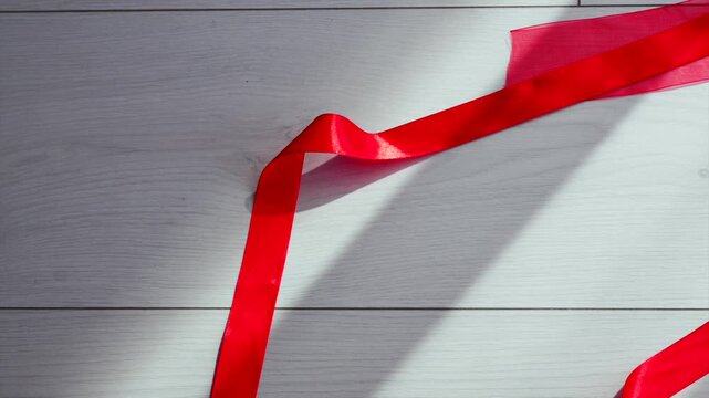 Birthday party.
Chic floor decor.
Long red ribbons in large print on the wooden floor.
Wrapping and gifts.
Christmas and red decor.