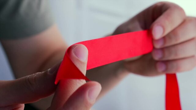 A red ribbon in a person's hands.
Satin ribbon and a festive mood.
Ribbon for wrapping fire extinguishers or flowers.
Red, ribbon, satin, long, bow