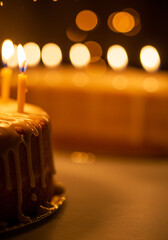 Birthday cake with lit candles in soft bokeh background  