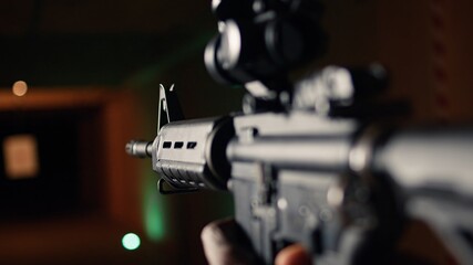 Shooting gallery client hitting paper targets with ammo, extreme close up of rifle. Close up of...