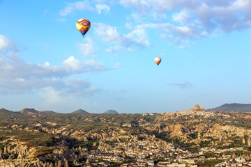 Aerial drone view of Uchisar Castle and Goreme National park with hot air balloons. Cappadocia, Turkey