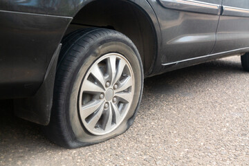 Black car flat tire on the road. © Nikolay N. Antonov