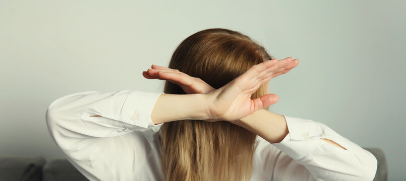 Woman shows stop, no or enough sign with palm of hand, refusal gesture, domestic violence