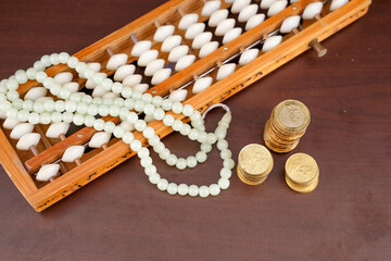 wooden abacus and pile of coins for islamic finance concept