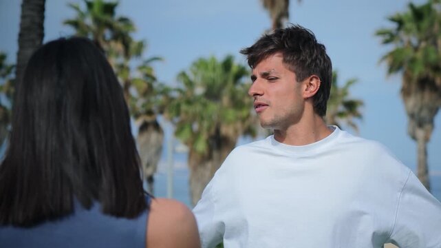 A young man engaged in an animated discussion with a woman, expressing emotions during a serious dialogue about relationship problems and issues they are facing together in an intense moment.