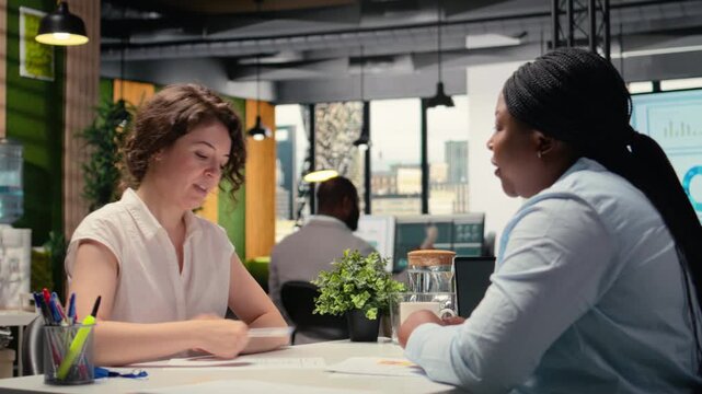 Black female applicant signing the new employment contract during job interview, accepted on the department team by the HR manager. Signature for paperwork agreement. New beginning. Camera A. - Powered by Adobe