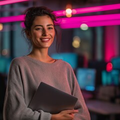smiling Hispanic woman in casual outfit holding laptop for coding bootcamp promotions, tech team branding, and coworking space visuals, low-light neon IT office, portrait format