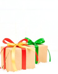 Two wrapped gifts, festive colors, snowy backdrop