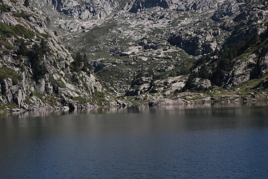 Fototapeta Tranquil mountain lake beckons with serene waters and rocky shores, inviting outdoor adventures and peaceful reflection in a captivating natural setting