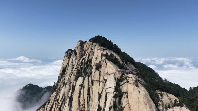aerial video of the Huashan mountain south peak amid sea of clouds, renowned Changkong Plank Road clinging to its sheer cliffs, Shaanxi province, China