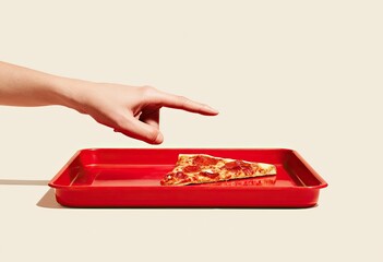 A hand reaches for a pizza slice on a red tray