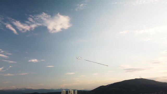 Kite Soaring Above Skopje: Breathtaking Aerial View of Cityscape, Vodno Mountain, and Cloudy Sky