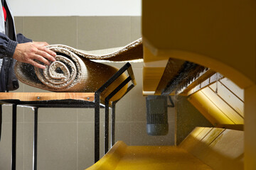 Male worker cleaning carpet on automatic washing machine equipment and dryer in the Laundry room....