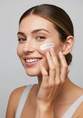 Young woman applying facial skincare cream