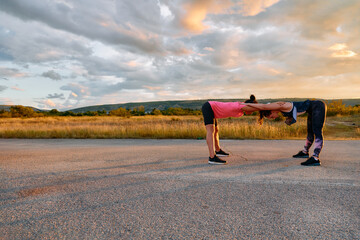 Two Women Athletes Stretching at Sunset in Beautiful Natural Surroundings