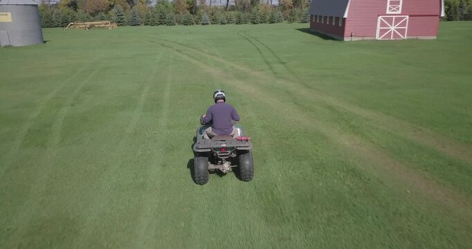 four wheeler ATV driven through hay field with labrador retriever