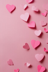 Pink paper hearts gently float across a pink textured background, evoking love, romance, and Valentine's Day sentiment.