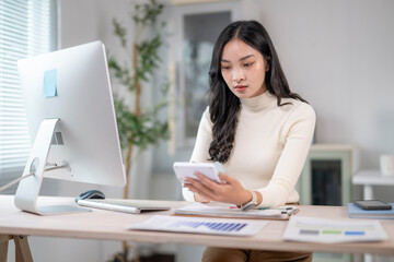 Businesswoman calculating tax using calculator at office desk