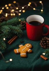 Gingerbread cookie resting on a green linen table with coffee