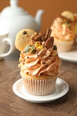 Delicious cupcakes with colorful cream and decor on wooden table, closeup