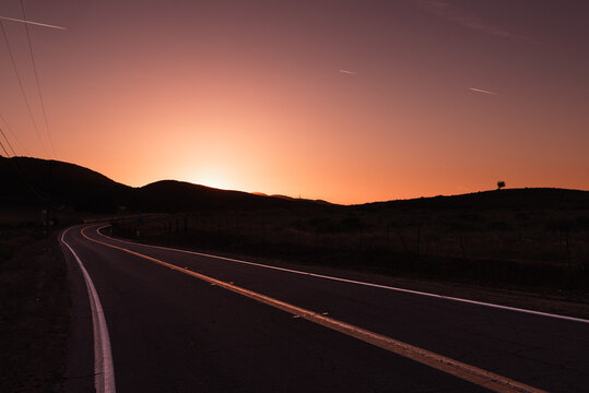 Winding valley road leading to sunset