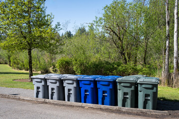 Preparation for large event in public park, garbage, recycle, and yard waste cans rolling cans and...