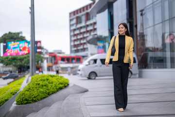 Businesswoman walking in city center, modern architecture and urban lifestyle