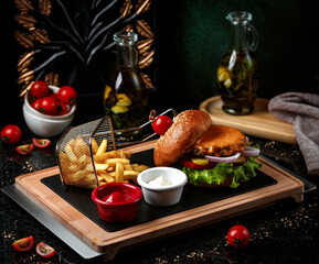 cheeseburger with french fries on wooden board