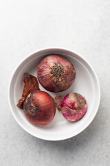 Overhead view of purple onions on white granite countertop, top view red onions on a white background