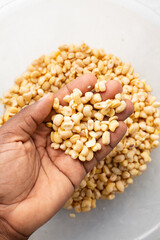 Overhead view of peeled beans, top view of blackeyed beans washed to make nigerian moi-moi or bean cake, process of peeling beans skin by hand