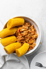 overhead view of Boiled ripe plantain with tomato scrambled eggs in a white bowl, top view of nigerian egg and plantain © this_baker