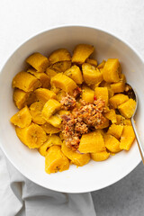 overhead view of Boiled ripe plantain with tomato scrambled eggs in a white bowl, top view of nigerian egg and plantain