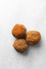 Overhead view of fried scotch eggs on white countertop