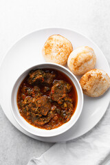 Overhead view of a plate of masa and miyan taushe, top view of food from northern nigeria masa and taushe, nigerian ethnic foods