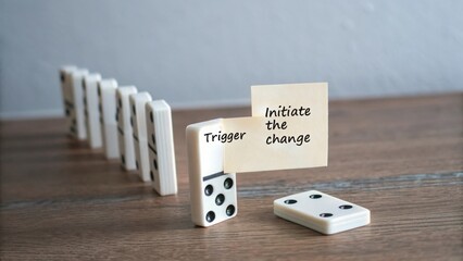 Single domino about to trigger the initiate change