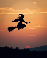 Elegant Witch Silhouette Against an Orange-to-Black Gradient Sky