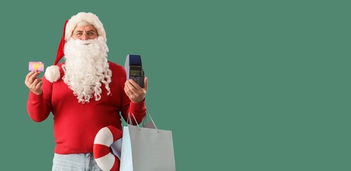 Santa Claus with credit card, payment terminal and shopping bags on green background with space for...