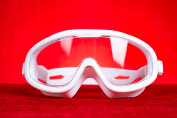 white swimming goggles on a red background