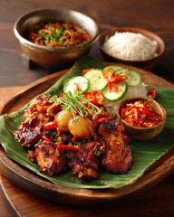 Spicy Grilled Chicken with Rice and Fresh Vegetables on Banana Leaf