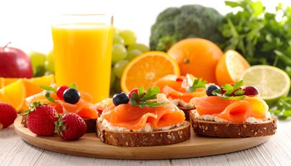 Healthy breakfast scene featuring smoked salmon toasts, fruits and juice